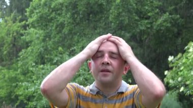 adam yaz yağmur altında stand ve dua etmek için elini kaldır. 4k