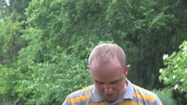 Worker man wash himself under heavy rain after hard hot working day. 4K