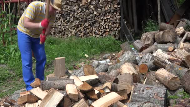 Un trabajador fuerte corta leña en el tronco, deja el hacha y aléjate. 4K — Vídeo de stock