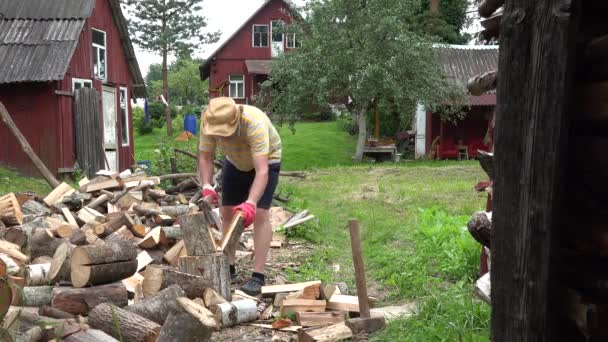 Young worker man chop alder log in village yard summertime. 4K — 비디오