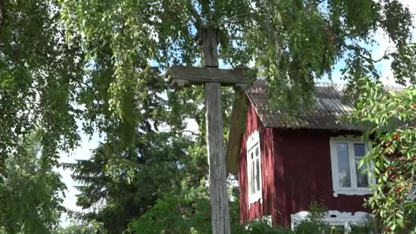 Cruz casera vintage y casa de madera de campo en el jardín. 4K — Vídeo de stock