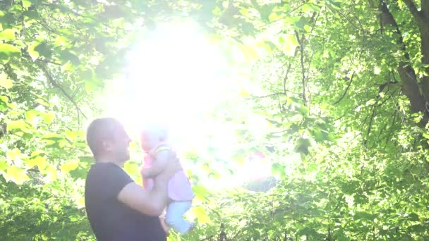 Baby met vader genieten van een zonnige dag zonlicht doorbladeren. 4k — Stockvideo