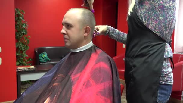 Cabeleireiro fazendo corte de cabelo para o jovem homem sorridente no salão de beleza. 4K — Vídeo de Stock