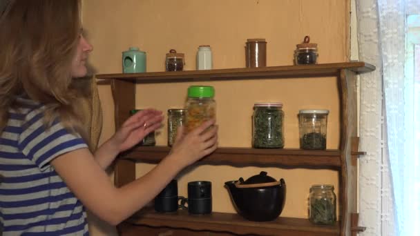 Jonge kruidkundige vrouw pick gedroogde kruiden uit glazen pot in vakantiehuis. 4k — Stockvideo