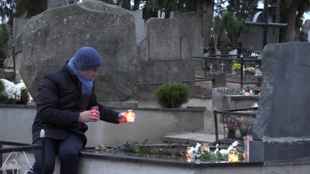 Vater Mann stellte Kerze auf Tochter Sohn Grab auf Friedhof. 4k — Stockvideo