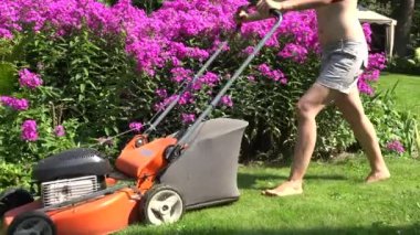 kadın yalınayak çiçek ile parkta çayır çim biçme makinesi kesti. 4k