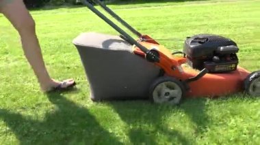 çim biçme makinesi ile kadın iş bahçesi kadar yakın. Çimleri kesmek. 4k