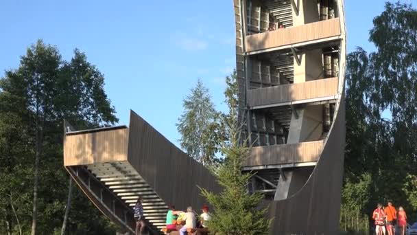 Los turistas visitan la inusual torre de observación en la naturaleza. Inclínate hacia arriba. 4K — Vídeos de Stock