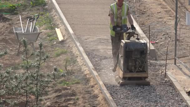 Arbetstryck spillrorna för kakel trottoaren trottoaren med plattan komprimator. 4K — Stockvideo