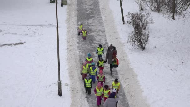 Los niños con niñera tienen paseo en el parque de invierno cubierto de nieve densa. 4K — Vídeo de stock