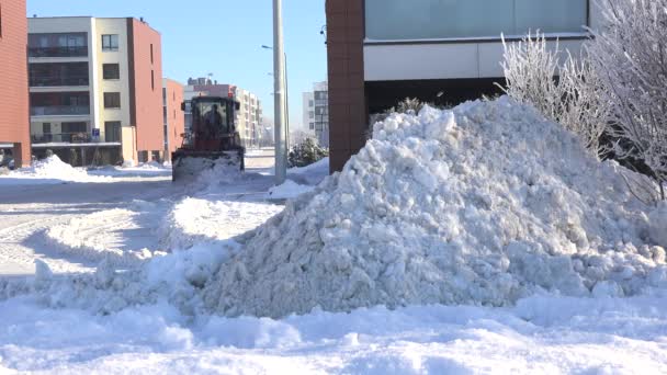 Ciągnika snowplow usunąć śnieg z ulicy dzielnicy miejskiego życia. 4k — Wideo stockowe