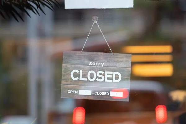 sorry we are closed sign hanging outside a restaurant, store, office or other