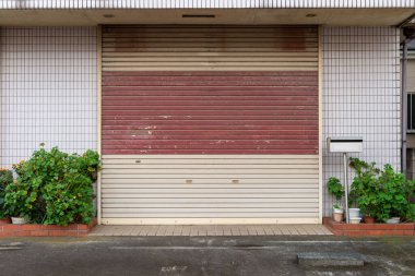 Fabrikada, depoda, garajda ve endüstriyel depoda kullanılan otomatik metal paten kapısının yakın çekimi. Bükülebilir ve katlanabilir metal levha yer tasarrufu sunuyor ve kentsel ve kırsal hissi sağlıyor