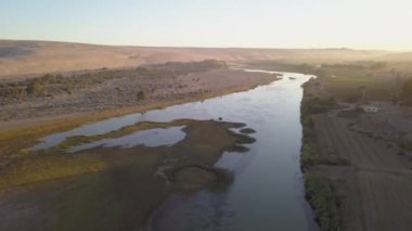 Nehir bir çöl manzarasında akıyor, havadan görünüyor.