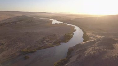 Nehir bir çöl manzarasında akıyor, havadan görünüyor.