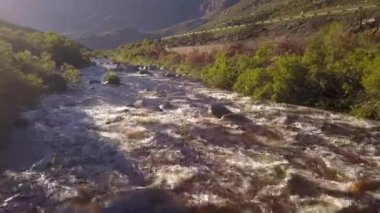 Açık bir kırsalda, küçük bir nehrin üzerindeki havadan.