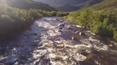 Açık bir kırsalda, küçük bir nehrin üzerindeki havadan.