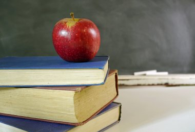 sınıf kitapları ile kırmızı elma