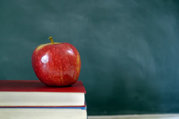 Red apple on books in classroom Stock Picture