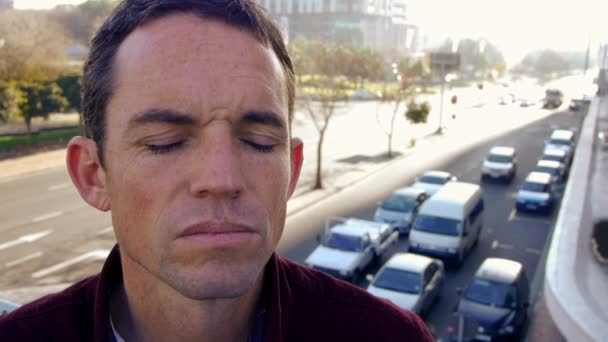Man closes his eyes to concentrate in the city — Stock Video