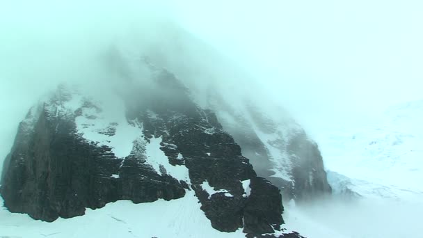 Schnee- und nebelverhüllter Berggipfel — Stockvideo