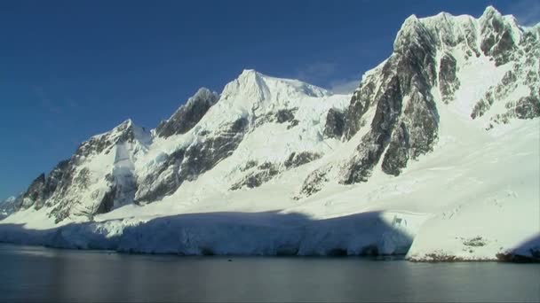 Schneebedecktes antarktisches Gebirge und ruhige See — Stockvideo