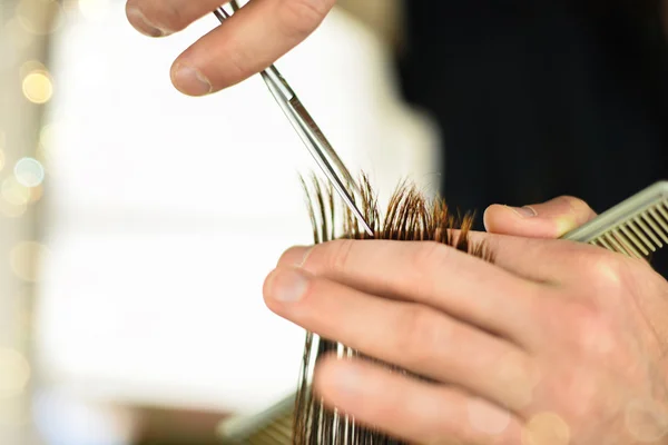 Les mains du coiffeur coupant les cheveux . — Photo