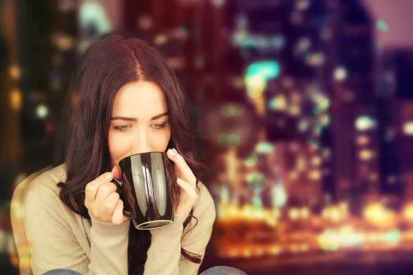 Attraktive junge brünette Frau mit einem Becher heißen Tee. — Stockfoto