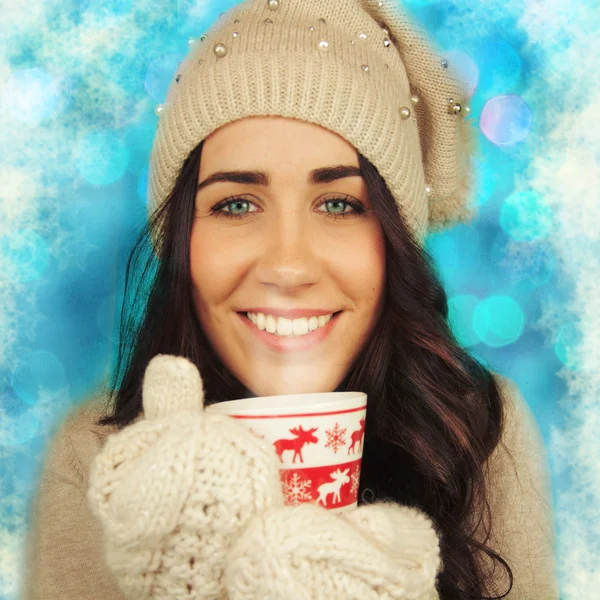 Young woman with cup on winter holiday background. — Stock Photo, Image