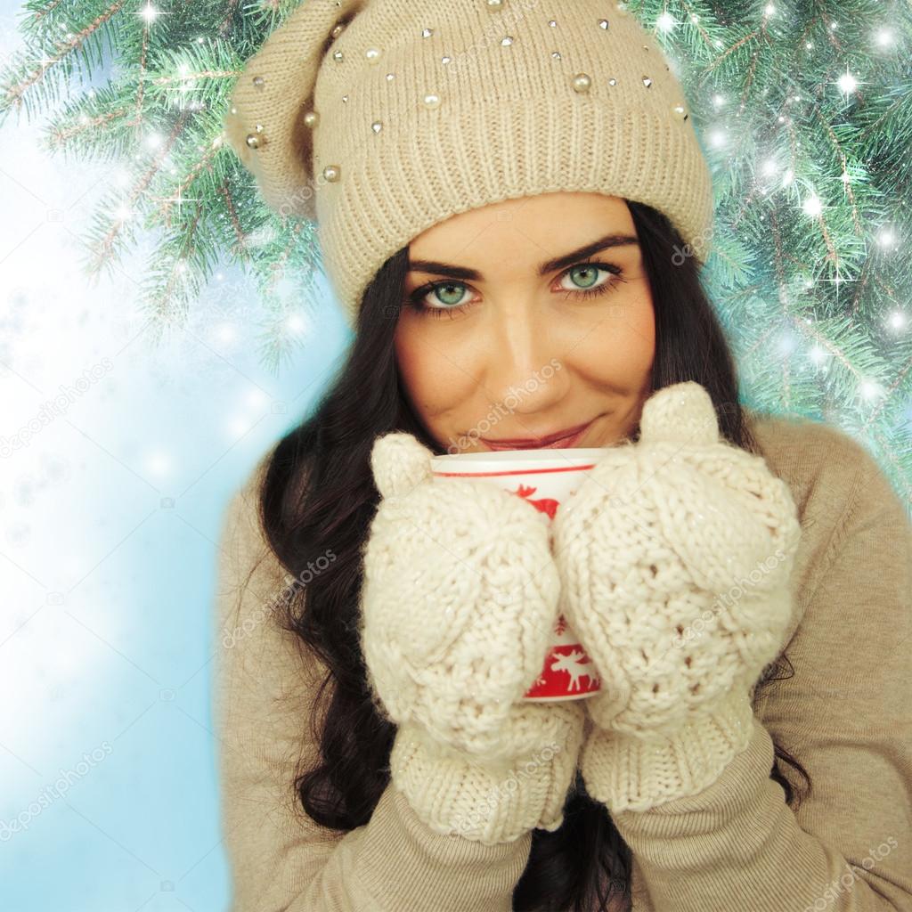Young woman with cup on winter holiday background.