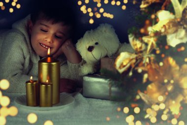 Noel ile evde ışık oynamak sevimli küçük çocuk portresi.
