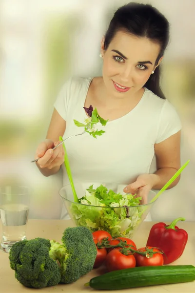 Portret van een aantrekkelijke blanke lachende vrouw die salade eet — Stockfoto