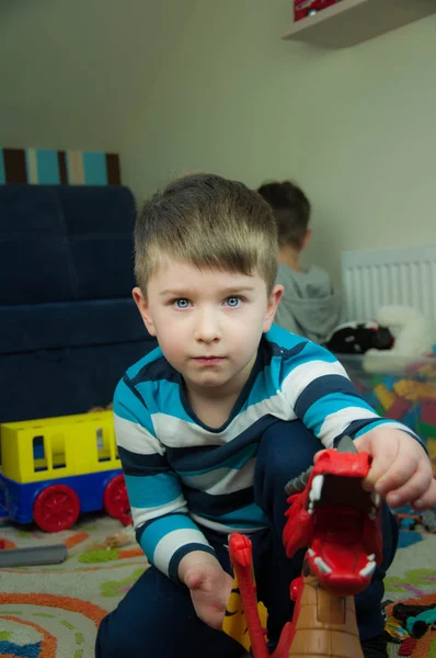 Rozkošné dítě chlapec hraje s automobily a hračky doma — Stock fotografie