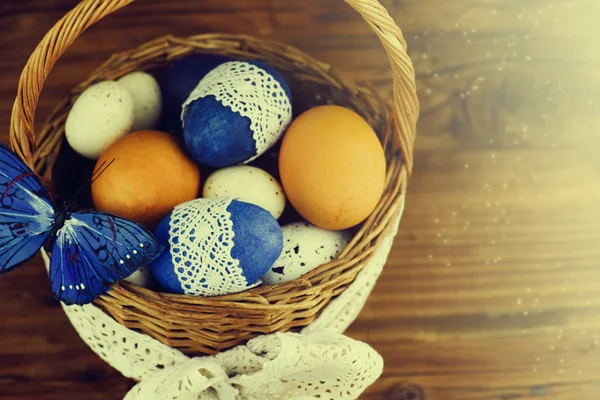 Huevos de Pascua en la cesta de tablas de madera . — Foto de Stock