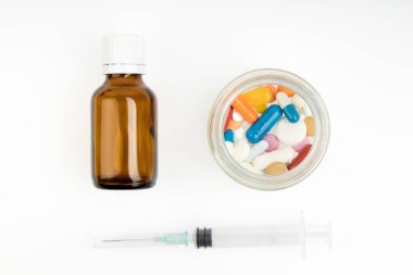 İlaçlar, vitaminler ve enjeksiyon için şırınga beyaz arka planda izole edilmiş ilaçlar