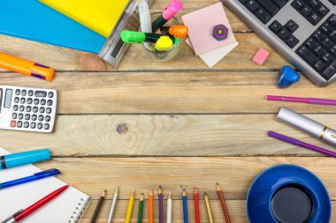 Ofis masası, bilgisayar, kalem ve bir fincan kahve, bir sürü şey. Kopyalama alanı olan üst görünüm