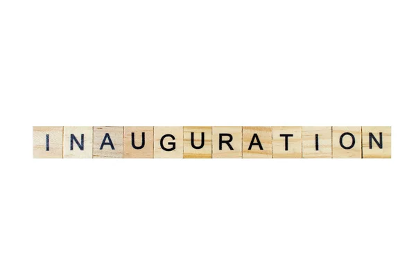 Inauguration . English word on white isolated background composed from letters on wooden cubes. Learning english concept