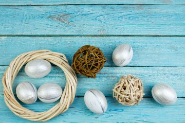 Mutlu Paskalyalar. Tahta arka planda yumurtalar... Toplar, sarmaşıklardan örülmüş çelenkler. Uzayı metin için kopyala. Üst görünüm