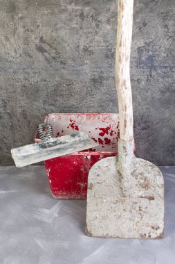 Eski, kirli kürek gri, kırmızı kovada, tuğlalar beton arka planda. Uzayı kopyala Üst görünüm