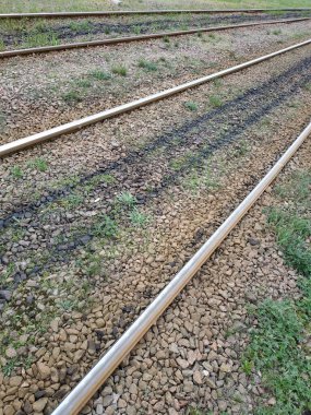 The rails go into the distance. Crushed stone, grass between the rails
