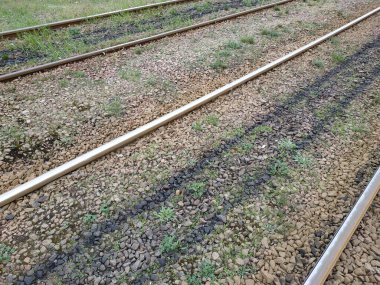 The rails go into the distance. Crushed stone, grass between the rails
