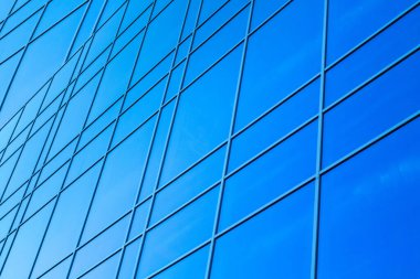 Cilalı cephe. Mavi bir arka planda donuk bir cephe. Şehir merkezinin modern gökdelenleri