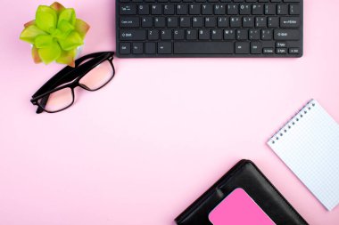 Bilgisayarlı pembe ofis masası, kalem ve bir fincan kahve, bir sürü şey. Kopyalama alanı olan üst görünüm