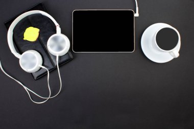 Bilgisayarlı siyah ofis masası, kalem ve bir fincan kahve, bir sürü şey. Kopyalama alanı olan üst görünüm