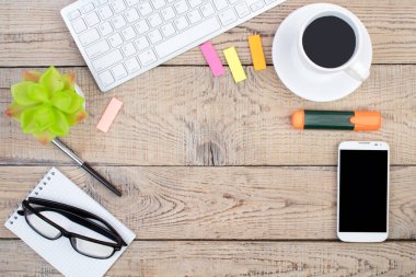 Bilgisayarlı ahşap ofis masası, kalem ve bir fincan kahve, bir sürü şey. Kopyalama alanı olan üst görünüm