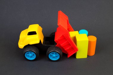 Çocuk oyuncağı, siyah arka planda çok renkli bir buharlı lokomotif. Çocuğun gelişimi için..