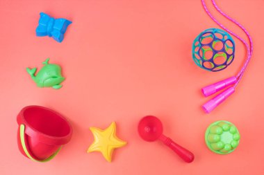 Çok renkli çocuk oyuncakları. Pembe bir arka planda.