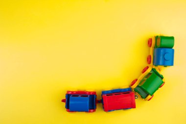 Çocuk oyuncağı, sarı arka planda çok renkli bir buharlı lokomotif. Çocuğun gelişimi için..