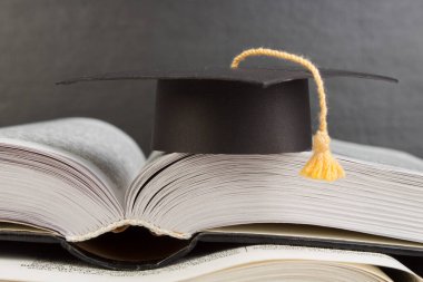 Ahşap güverte masası ve kara tahta arka planı üzerine açık bir kitap. Okula geri dön. Reklam metnin için kopyalama alanı olan eğitim kavramı