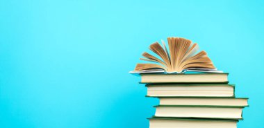 Açık bir kitap, ahşap masadaki ciltli kitaplar, mavi bir arka plan. Okula dönelim. Uzayı metin için kopyala. Eğitim geçmişi. panorama, pankart